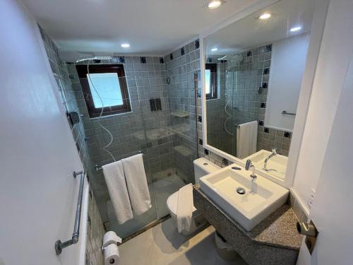 uma casa de banho com um lavatório, um WC e um espelho. em Flat no Hotel Jatiúca suítes resort em Maceió