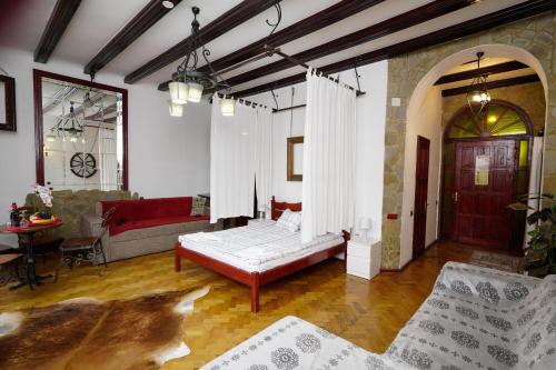 a bedroom with a bed and a couch and a table at Pensiunea Noemi in Braşov