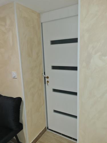 une porte dans une pièce avec une chaise noire dans l'établissement SPA 1001 Merveilles, à Fénay