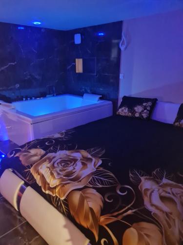 a room with a bed and a tub with purple lights at SPA 1001 Merveilles in Fénay