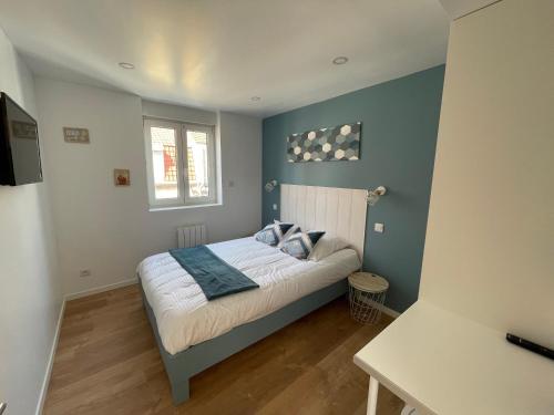 Un dormitorio con una cama con paredes azules y una ventana en l'étoile de mer - appartement le bord de mer, en Gravelines