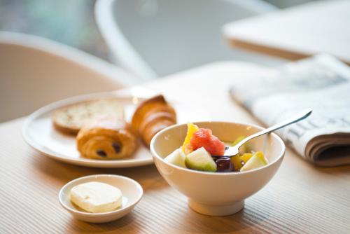 a table with a bowl of food and a plate of pastries at Nomad Paris Roissy CDG in Le Mesnil-Amelot