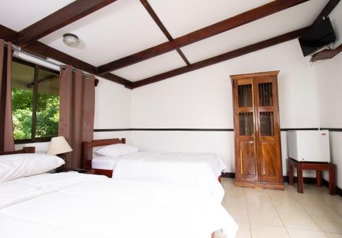 a room with three beds and a tv in it at Hacienda La Pacífica Eco-Lodge in Cañas