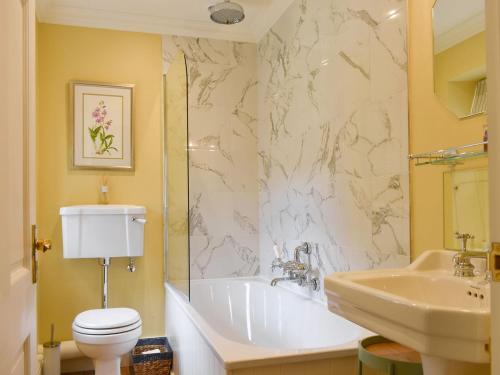 a bathroom with a tub and a toilet and a sink at 3 The Reading Room Cottages - Uk31802 in Barningham