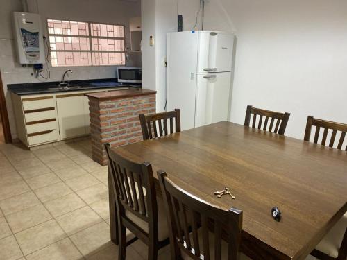 eine Küche mit einem Holztisch mit Stühlen und einem Kühlschrank in der Unterkunft casa centrica in Río Cuarto