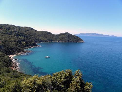 an island with a boat in a large body of water at Agriturismo Monte Alzato in Capalbio