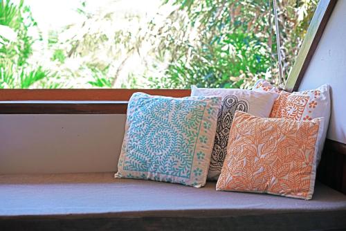 a group of pillows sitting on a window sill at Casa Cayuco Eco-Adventure Lodge in Bocas del Toro