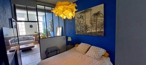 een slaapkamer met een bed en een blauwe muur bij LA ROCHELAISE : Appartement calme & somptueux dans l'hyper centre. in La Rochelle