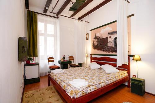 ブラショヴにあるPensiunea Noemiのベッドルーム1室(ベッド1台付)が備わります。壁には絵画が飾られています。