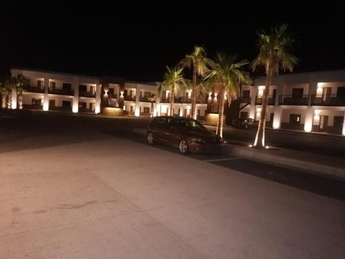 納沃華的住宿－RIVI GRAND HOTEL，棕榈树建筑前的停车场