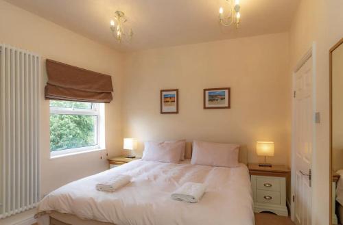 a bedroom with a white bed and a window at Park Crescent apartment in York