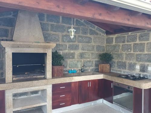 a kitchen with a stone wall with a fireplace at Casa da rosinha - Minho, Portugal in Arcos de Valdevez