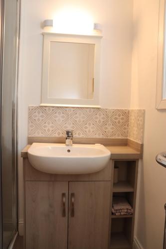 a bathroom with a sink and a mirror at Farmston Lodge in Callander