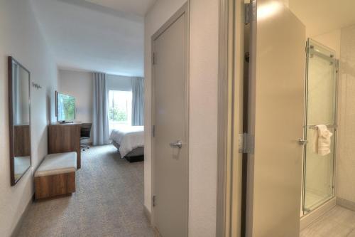 a hotel room with a bedroom and a bathroom at Holiday Inn & Suites Pigeon Forge Convention Center by IHG in Pigeon Forge