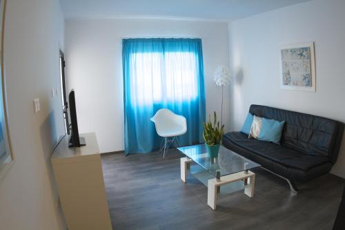 a living room with a black couch and a glass table at Margarita Napa Apartments in Ayia Napa