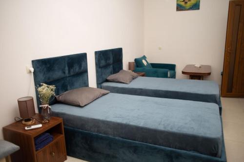 um quarto com 2 camas e uma cadeira em Apex rest house em Yerevan