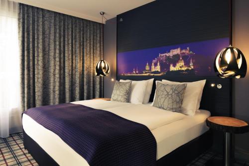 una camera d'albergo con un letto e un dipinto sul muro di Mercure Salzburg City a Salisburgo