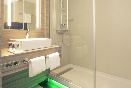 a bathroom with a sink and a shower at Mercure Salzburg City in Salzburg