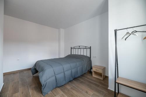 1 dormitorio con 1 cama y suelo de madera en El Rincón de Ramón II en Cortijos Nuevos