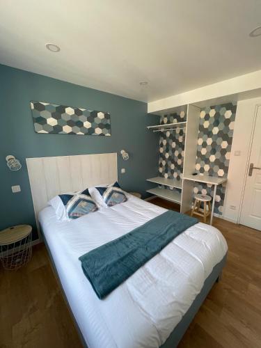 1 dormitorio con 1 cama grande con sábanas blancas y paredes azules en l'étoile de mer - appartement le bord de mer, en Gravelines