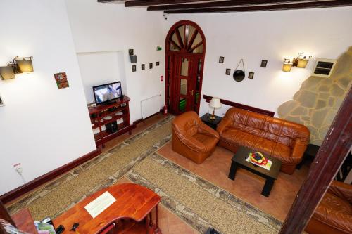 a living room with a leather couch and a tv at Pensiunea Noemi in Braşov