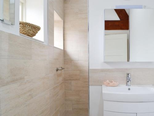 a bathroom with a sink and a mirror at Plas Bach in Llanon