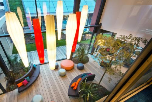a view of a building with lights and chairs at Nomad Paris Roissy CDG in Le Mesnil-Amelot