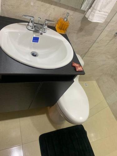 a bathroom with a white sink and a toilet at Maravilloso chalet en la zona colonial (303) in Zipaquirá