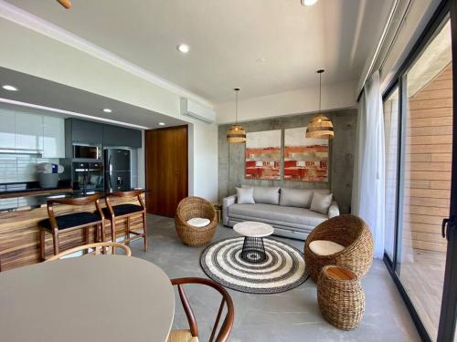 a living room with a couch and a table and chairs at Departamento catania con vista al mar in Mazatlán