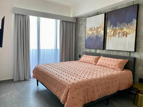 a bedroom with a large bed with pink pillows at Departamento catania con vista al mar in Mazatlán