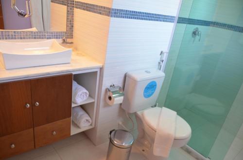 ein Bad mit einer Dusche, einem WC und einem Waschbecken in der Unterkunft Casa Centro Búzios in Búzios