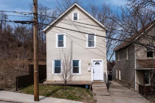 una casa blanca con una puerta blanca en Tremont! 7 min to downtown Cleveland en Cleveland