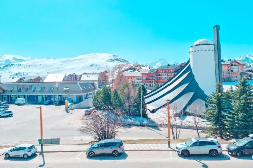 a group of cars parked in a parking lot at Beautiful flat in L'Alpe d'Huez heart at the foot of the slopes - Welkeys in LʼHuez