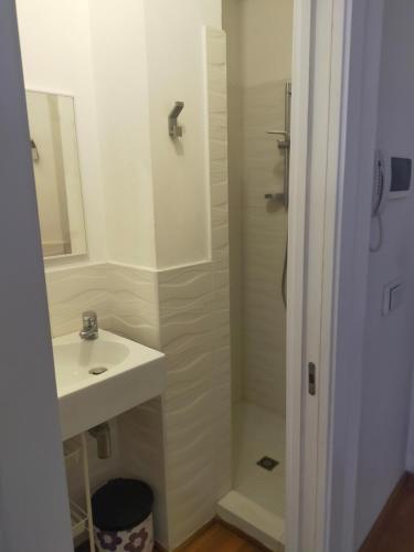 a white bathroom with a sink and a shower at Monolocale Fiera in Bologna