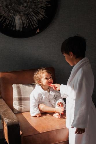 a boy feeding a little girl a piece of food at Fairmont Chateau Whistler in Whistler