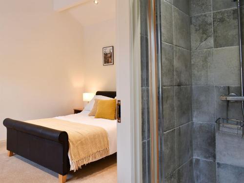 a bedroom with a bed and a shower at Swaledale Cottage - Barley Green Mill in Barrowford