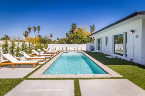 uma piscina com espreguiçadeiras ao lado de uma casa em White Pearl - Pool - Spa - Mountain Views em Palm Springs
