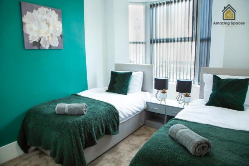 a bedroom with two beds with green and white at Spacious 3 Bed City Centre House for Large Groups and Contractors with Free Wifi by Amazing Spaces Relocations Ltd in Liverpool