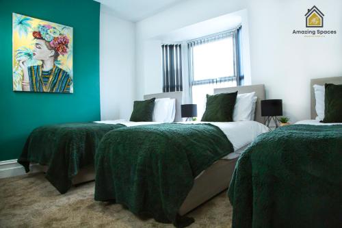 two beds in a room with green and white at Spacious 3 Bed City Centre House for Large Groups and Contractors with Free Wifi by Amazing Spaces Relocations Ltd in Liverpool