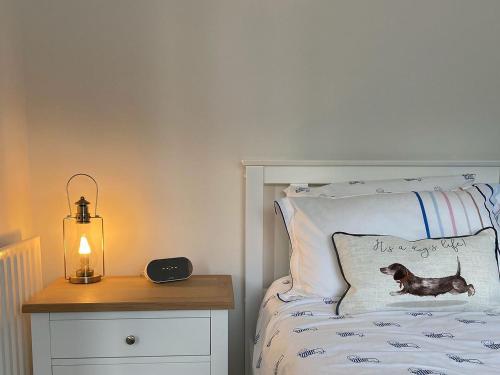 Old Brampton的住宿－Oakleigh，床上配有枕头,床头柜上配有灯