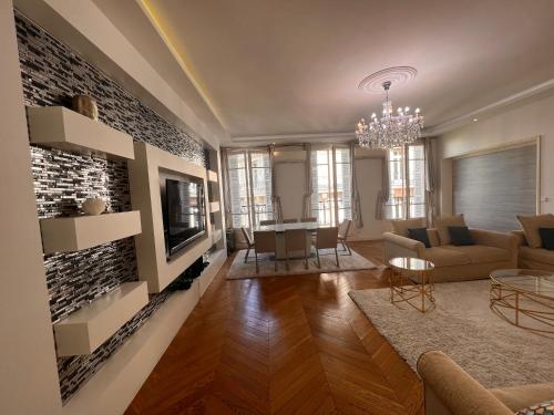 een woonkamer met een bank en een tv bij Appartement Champs-Élysées - HALA PARIS in Parijs