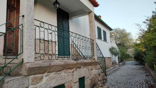 a building with a balcony and a stone street at Quinta da Barbosa in Folgosinho