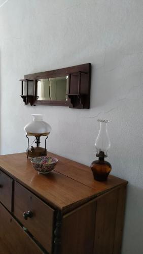 a wooden dresser with a mirror and two lamps on it at Quinta da Barbosa in Folgosinho