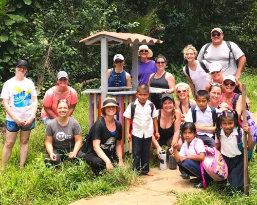 a group of people posing for a picture in front of a structure at Casa Cayuco Eco-Adventure Lodge in Bocas del Toro