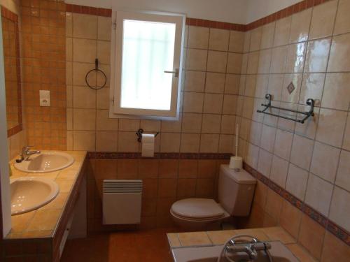 吕斯特勒Maison de vacances avec piscine privative, Oustau des Oliviers vue dominante Colorado provençal的一间带卫生间和两个盥洗盆的浴室以及窗户。