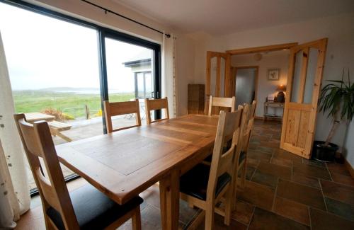 a dining room with a wooden table and chairs at Cottage 103 - Claddaghduff in Cleggan