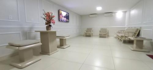 a salon with a waiting room with chairs and flowers at Hotel Presidente in Imperatriz