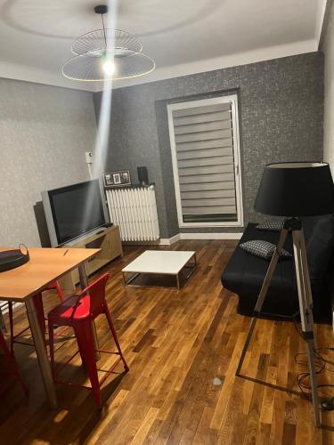 a living room with a couch and a table at Studio à proximité de Laval in Soulgé-sur-ouette