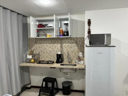 a small kitchen with a refrigerator and a microwave at Flat Rosebahia in Morro de São Paulo