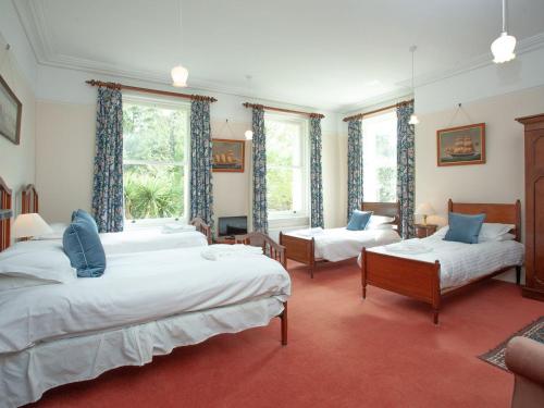 a large bedroom with two beds and two chairs at Longcroft House in Torquay